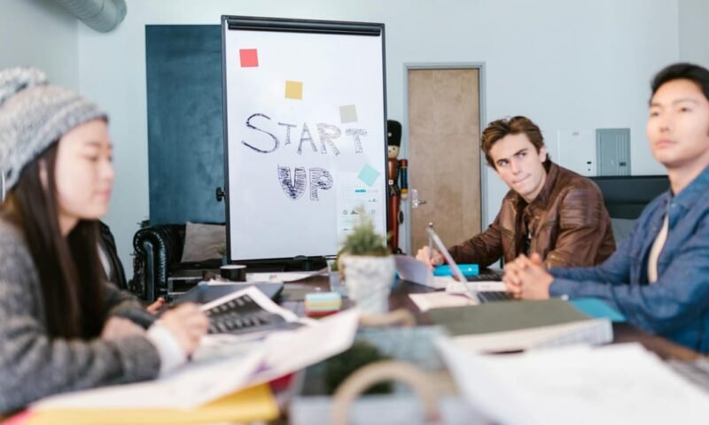 A group of young professionals brainstorming ideas in a startup office setting.